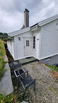 two benches sitting in front of a building at Leilighet v Hardangerfjorden in Hesthamar