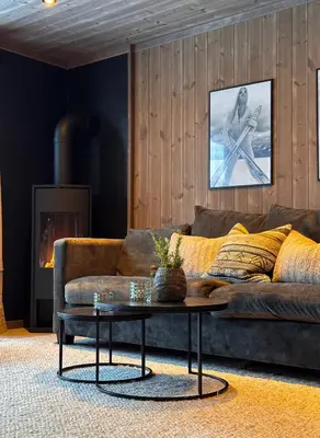 a living room with a brown couch and a coffee table at Norebu - Norefjell in Noresund
