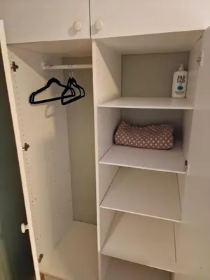 a walk in closet with white shelves at Rom 4 i bufellesskap in Sogndal