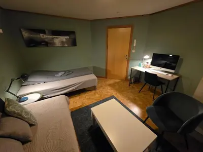 a small room with a bed and a desk with a computer at Rom 4 i bufellesskap in Sogndal