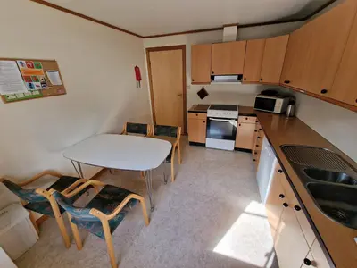 a small kitchen with a table and chairs in it at Rom 4 i bufellesskap in Sogndal