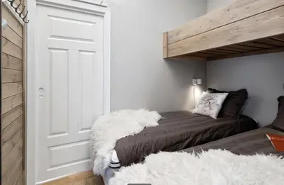 a bedroom with a bed with a white blanket at Geilo sentrum for 4 personer in Geilo