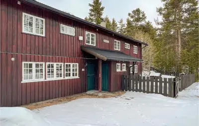 a red barn with a fence in the snow at Gorgeous Apartment In Espedalen in Espedalen