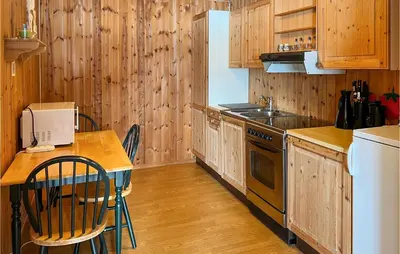 a kitchen with wooden cabinets and a table and a stove at Gorgeous Apartment In Espedalen in Espedalen