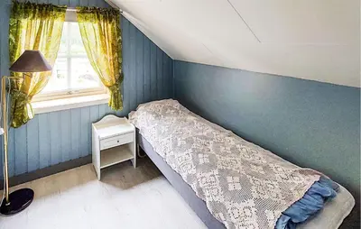 a small bedroom with a bed and a window at Beautiful Home In Vallavik With Kitchen in Djønno