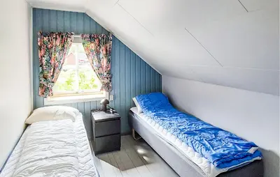 a small room with two beds and a window at Beautiful Home In Vallavik With Kitchen in Djønno