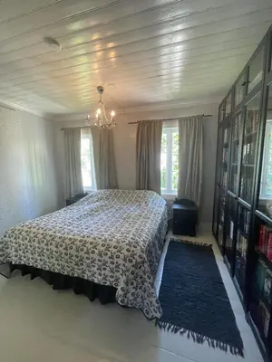 a bedroom with a bed and a chandelier at Sandstad, Lilleby i Trondheim in Trondheim