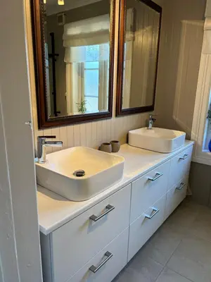 a bathroom with two sinks and a mirror at Sandstad, Lilleby i Trondheim in Trondheim