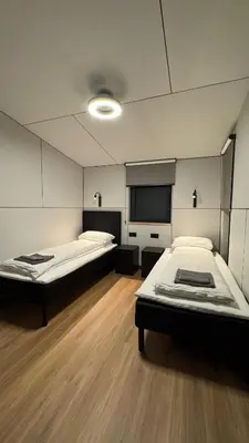 a room with two beds and a flat screen tv at Nothaugen AS in Nordheim