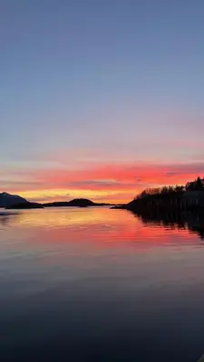 a large body of water with a sunset in the background at Nothaugen AS in Nordheim