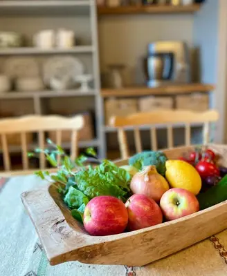 a wooden bowl of fruit and vegetables on a table at Secluded Holiday Home, With private beach in Ålesund
