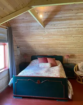 a bedroom with a bed in a room with wooden walls at Secluded Holiday Home, With private beach in Ålesund