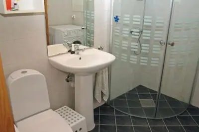 a bathroom with a sink and a shower and a toilet at Spacious house by the Hardangerfjord in Hesthamar