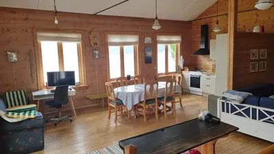 a kitchen and living room with a table and chairs at Spacious house by the Hardangerfjord in Hesthamar